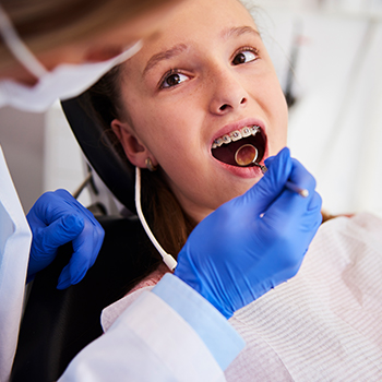Young girl getting her braces examined