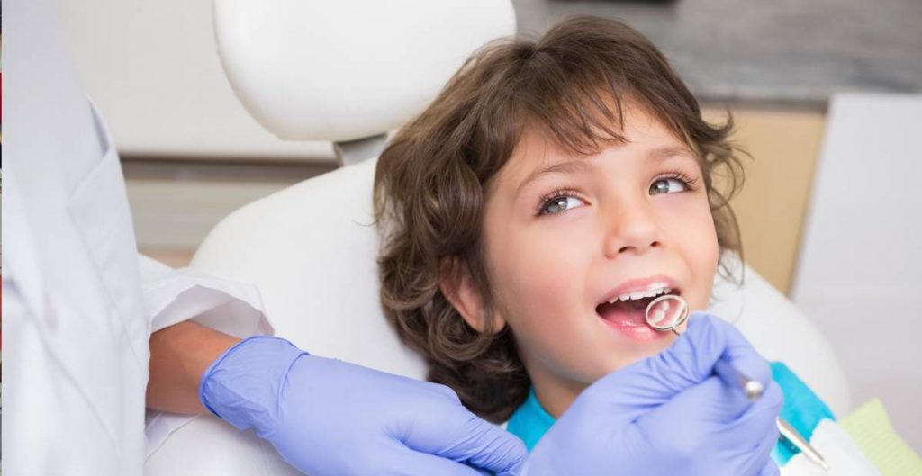 Young boy getting his teeth examined